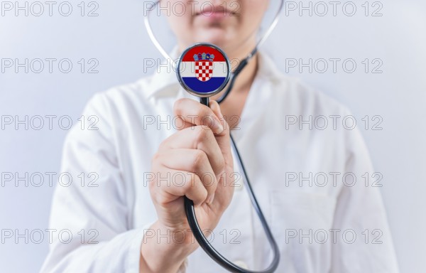 Female doctor holding stethoscope with Croatian flag. National health system of Croatia