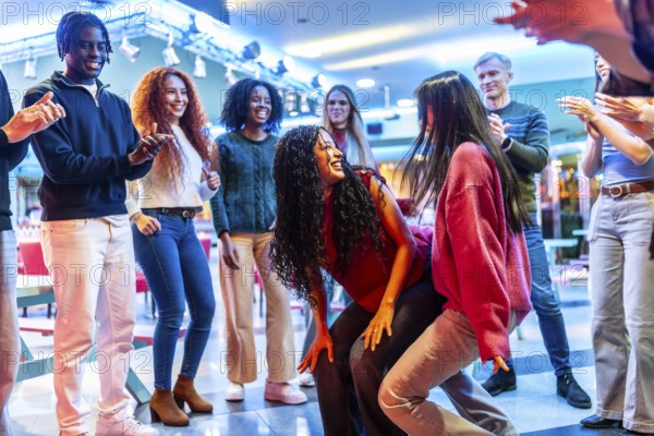 Young people having fun dancing at the bowling alley, enjoying their weekend together with energy and enthusiasm