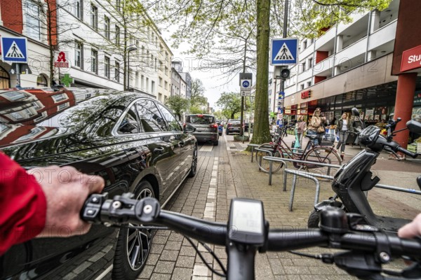 Cycling in the city, inner-city street, cycle lane, bicycles have priority, two-lane traffic with parked cars on both sides, cyclists' perspective, Essen, North Rhine-Westphalia, Germany, Europe