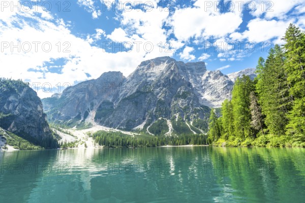 Emerald waters reflecting the majestic dolomites peaks at lake braies, a stunning natural wonder in the heart of the italian alps