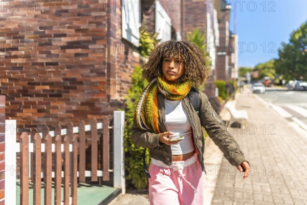 Latin female beauty student leaving the house and walking in a sunny day of autumn