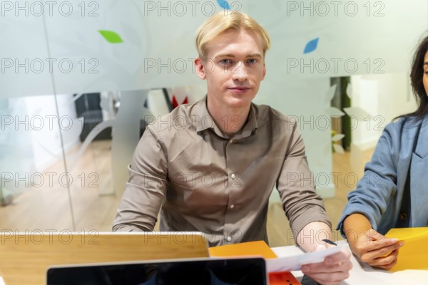Two colleagues working together on a project in a modern coworking space, sharing ideas and documents