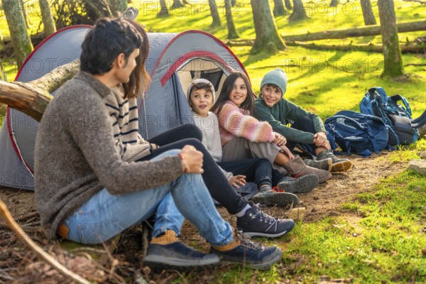 Caucasian family with three child enjoying a weekend camping in the forest together