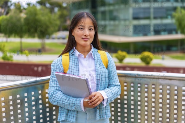 Three quarter length portrait of a beauty female asian student standing proud outside the university