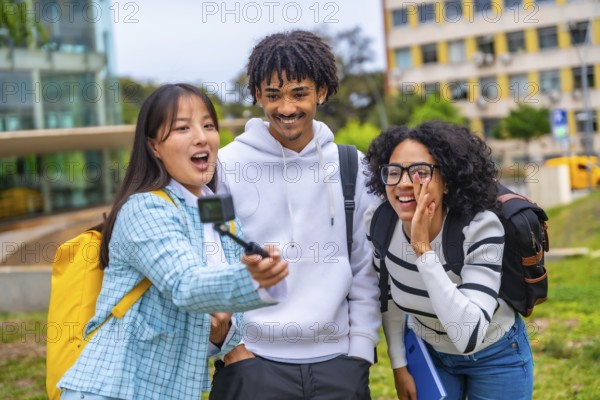 Three cool multi-ethnic students talking selfie with wearable camera and tripod
