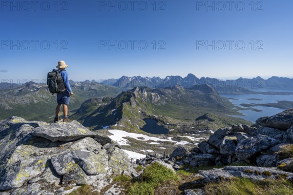 View of mountain landscape, mountain panorama, mountaineer at the summit of Rundfjellet, lake Hellskarvatnet, Svolvaer, Nordland, Norway, Europe
