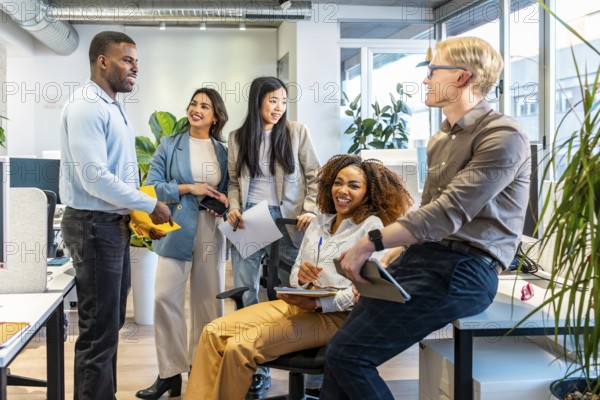 Diverse colleagues interacting, sharing ideas, and working together in a bright, open plan office space