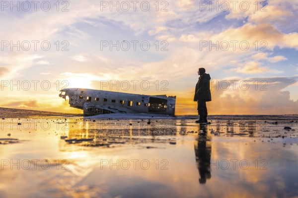 Young adventurous man at sunrise on Solheimasandur plane in winter in Iceland
