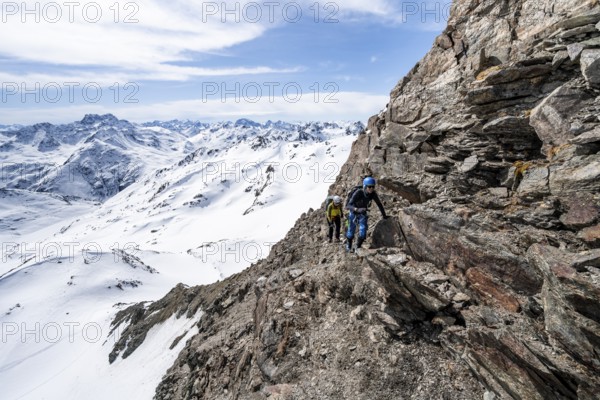Two mountaineers climbing up a narrow mountain path, ascent to the summit of Piz Grialetsch in winter, Grisons Haute Route, Albula Alps, Rhaetian Alps, Grisons, Switzerland, Europe