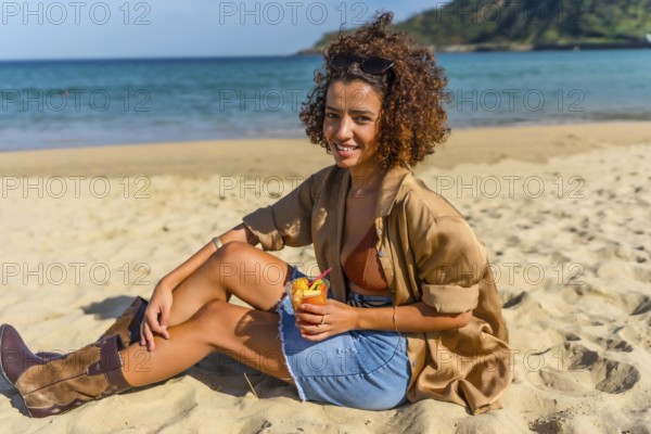 Arab young beauty woman sitting on a sandy beach enjoying tropical fruit sliced on a plastic glass