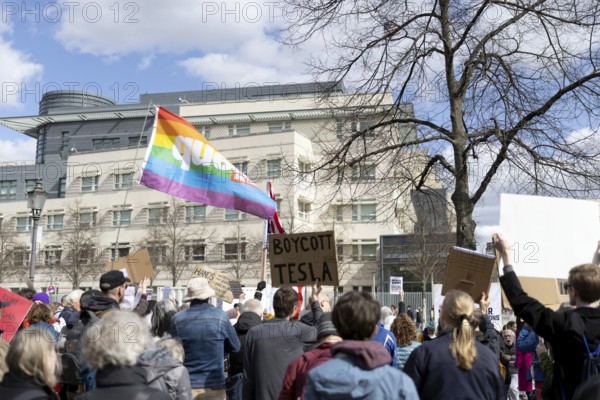 Berlin, Germany - 5 April 2025: A protester holds a sign reading Boycott Tesla as he demonstrates with others in front of the US Embassy in Berlin against the policy of US President Donald Trump and his advisor, Tesla owner Elon Musk, under the slogan Hands Off