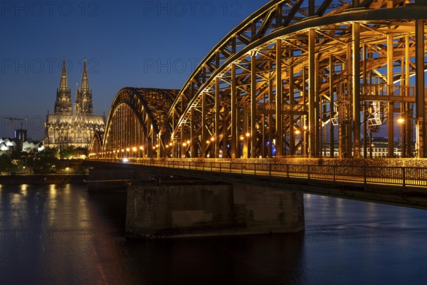 Cologne Cathedral, has been shining in new light since Easter 2025, the old metal halide lamps have been replaced by over 700 modern LED lamps, reducing energy consumption by around four fifths, significantly improving the quality of light and greatly reducing light emissions, 12 KM of new cables were laid for this, Hohenzollern Bridge, railway bridge over the Rhine, North Rhine-Westphalia, Germany, Europe