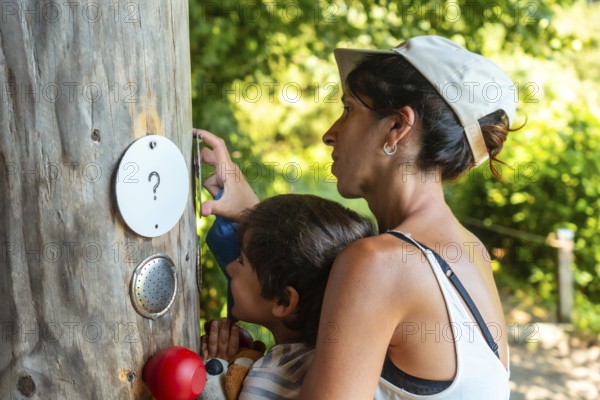 Mother and son touching a tree in a sensory park to enjoy nature and the senses, Black Forest, Germany, Europe