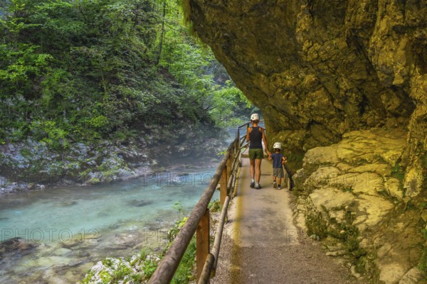 Tourists walking along the radovna river in vintgar gorge, near bled, slovenia, enjoying the stunning scenery and peaceful surroundings