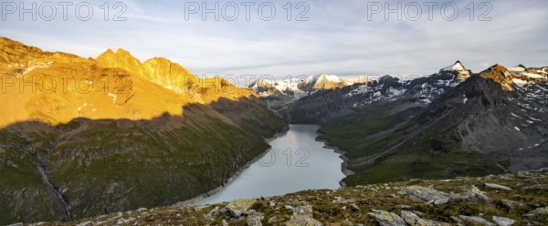 Picturesque mountain landscape at the summit Mont de la Blana at sunset, view of blue mountain lake, reservoir Lac des Dix and summit Mont Blanc de Cheilon with glacier, Hérémence, Valais, Western Alps, Switzerland, Europe