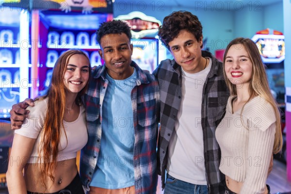 Four young multiethnic friends are smiling and having fun at an arcade, enjoying the weekend together