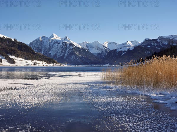 Frozen Sihlsee, reservoir, behind the snow-covered mountains Flübrig and Druesberg, Euthal, Canton Schwyz, Switzerland, Europe
