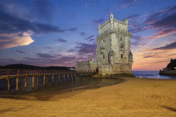 Belem Tower or Tower of St Vincent, famous tourist landmark of Lisboa and tourism attraction, on the bank of the Tagus River (Tejo) after sunset in dusk twilight with dramatic sky. Lisbon, Portugal, Europe