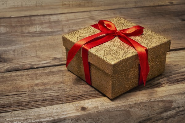Gift present birthday Christmas concept, gift box with red ribbon on wooden background