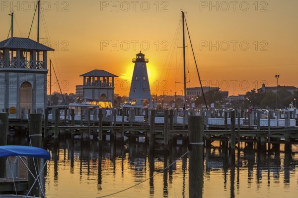 Setting sun behind lighthouse at the Small Craft Harbor in Gulfport, Mississippi, USA, North America