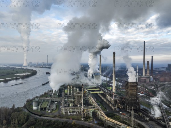 Duisburg, Ruhr area, North Rhine-Westphalia, Germany, ThyssenKrupp Steel Europe, steelworks with coking plant Schwelgern KBS thyssenkrupp Steel in Duisburg-Marxloh on the Rhine, at the back left the STEAG Walsum power plant, a coal-fired power plant in Duisburg-Walsum. Theme picture: COP28, the United Nations Climate Change Conference 2023, will take place in Dubai from 30 November to 12 December. At the 2015 climate summit in Paris, the international community agreed on the 1.5-degree target to avert a climate catastrophe, Europe