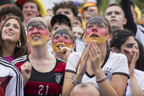 Women wearing make-up in the German national colours watch the football match in the fan zone at the Brandenburg Tor during the quarter-final match between Germany and Spain at the European Football Championship, Berlin, 05.07.2024