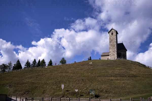 Hikers in front of St. Vigilius church, Vigilius on the yoke, faith trail, near Lana, South Tyrol, Autonomous Province of Bolzano, Italy, Europe