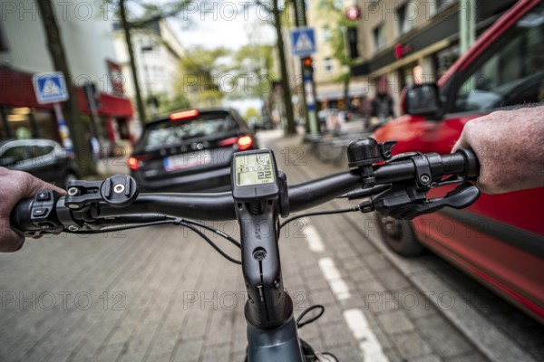 Cycling in the city, inner-city street, cycle lane, bicycles have priority, two-lane traffic with parked cars on both sides, cyclists' perspective, Essen, North Rhine-Westphalia, Germany, Europe