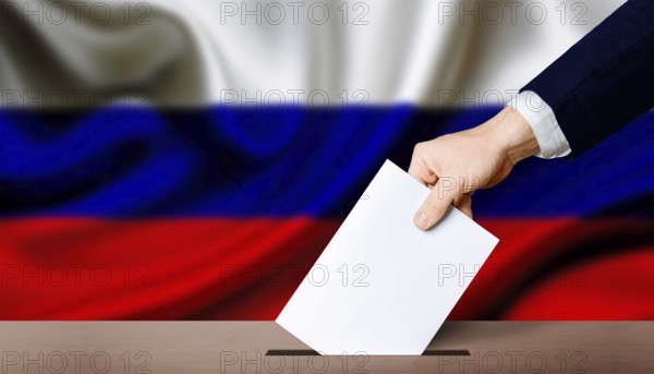 Presidential elections of the Russian Federation. Hand holding ballot in the ballot box with Russia flag in the background