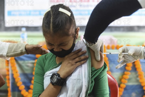 A health worker inoculates a student with a dose of a Covid-19 coronavirus vaccine during a vaccination drive for people in the 15-18 age group at a school in Guwahati, Assam, India on January 3, 2022. India has detected more than 1, 700 cases of Omicron variant of novel coronavirus infection