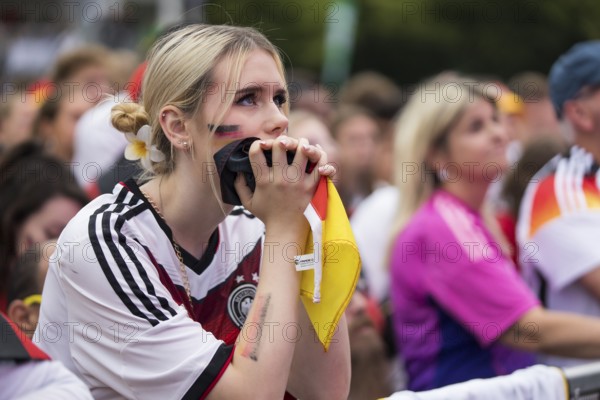 A woman watches the football match in the fan zone at the Brandenburg Tor during the quarter-final match between Germany and Spain at the European Football Championship, Berlin, 05/07/2024