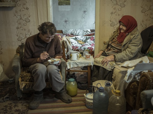 Varvara, 85, and her son Leonid, 56. Leonid looks after his mother, who is in need of care. She herself, Leonid and his brother live off the old woman's small pension. In Borshchivka, people only survive thanks to humanitarian aid, the front is only a few kilometres away as the crow flies, Borshchivka, Raion Isjum, Kharkiv Oblast, Ukraine, Europe