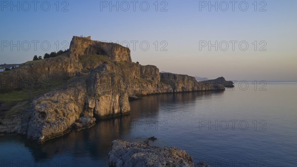 Drone shot, first morning light, Lindos, Acropolis of Lindos, Picturesque castle on a cliff overlooking the sea caught in the stillness of dusk, Archaeological site, Lindos, Rhodes, Dodecanese, Greek Islands, Greece, Europe
