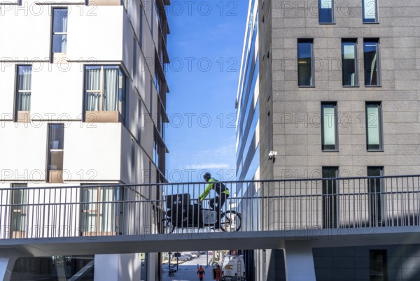 The Parkbruk, cycle and pedestrian bridge in the city centre of Antwerp, crosses a multi-lane city centre road with tram lines and thus connects two lively city districts Kop Spoor Noord and Eilandje, 140 metres of curved ramp on the western side for driving up and down, walking, Belgium, Europe