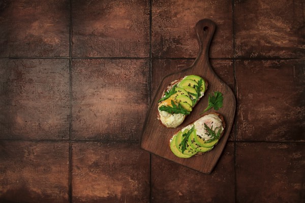 Sandwich with cream cheese, sliced avocado and boiled egg, arugula, on grainy bread, homemade, breakfast, no people
