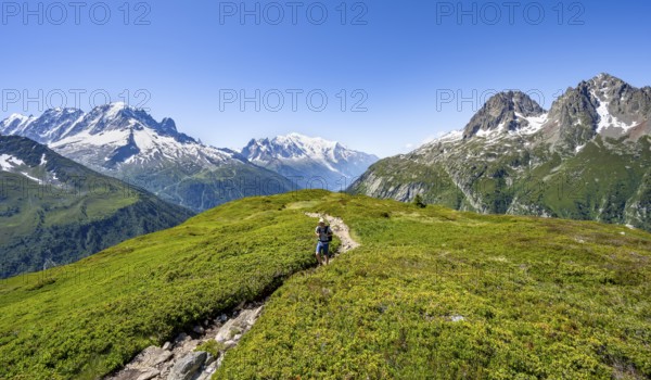 Mountaineer on hiking trail, mountain panorama with glaciated mountain peaks, Aiguille Verte with Aiguille du Midi and Mont Blanc, hike to Aiguillette des Posettes, Chamonix, Haute-Savoie, France, Europe