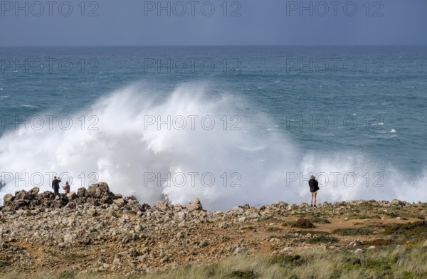 Carrapateira, Algarve, Portugal - Tourists on a viewing platform marvel at the roaring surf and spray not far from Praia do Bordeira on a stormy spring day. Carrapateira is a village in the municipality of Bordeira in the south of Portugal. It is located in the Parque Natural do Sudoeste Alentejano e Costa Vicentina, Southwest Alentejo and Costa Vicentina nature park Park