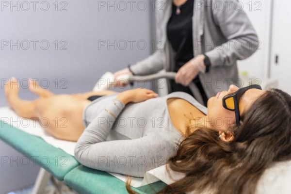 Woman with safety glasses lying comfortable during laser hair removal procedure in a beautician clinic