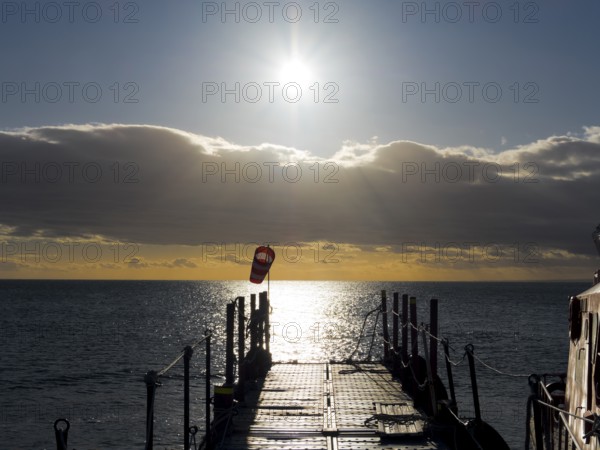 Jetty at sunrise over the sea on the Strait of Magellan, Punta Arenas, Chile, South America
