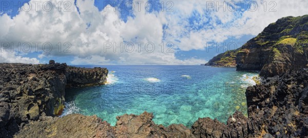 Panoramic view of a rocky lava coast with clear blue water and clouds in the sky, Termas da Ferraria, Sao Miguel Island, Azores, Portugal, Europe