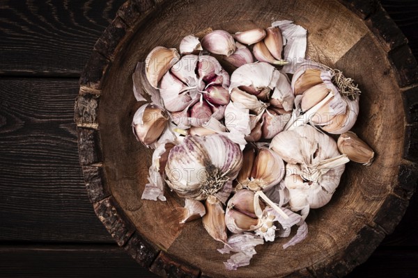 Fresh garlic, in a wooden plate, top view, close-up, no people