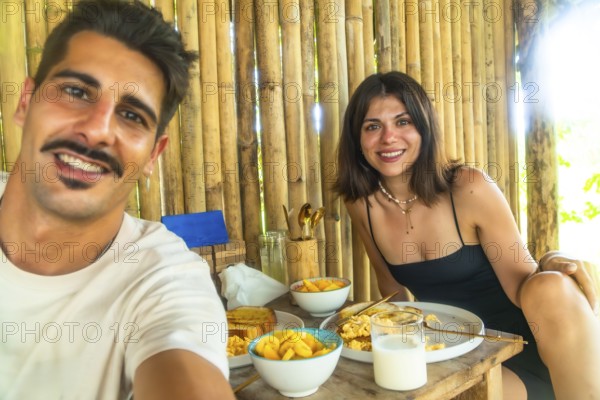 Tourists having breakfast with mango and scrambled eggs in a bamboo hut during their holidays in siargao island, philippines