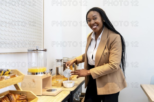 Businesswoman enjoying breakfast at hotel buffet, pouring milk into cereal bowl, showing healthy lifestyle during business trip