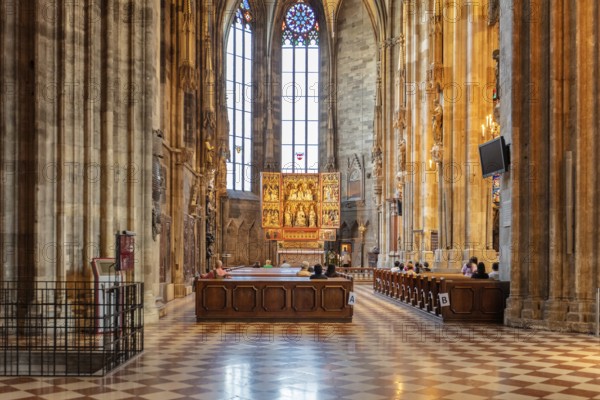 Bright Gothic church interior with impressive windows and decorated altar, Vienna