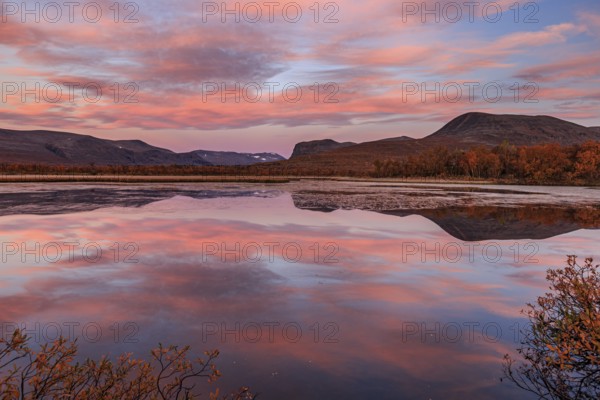 Mountains reflected in lake, autumn colours, cloudy mood, morning light, dawn, Nikkaluokta, Laponia, Lapland, Sweden, Europe