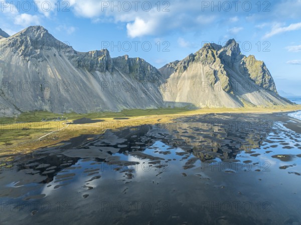 Aerial view of Mt. Vestrahorn, black lava beach, reflections on the water, Stokksnes, east of Höfn, East Fjords, Iceland, Europe