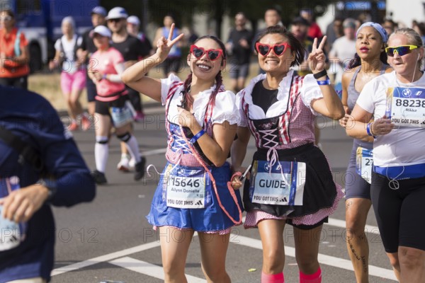 Runners in dirndls on Karl-Marx-Allee at the 50th BMW Berlin Marathon 2024 on 29 September 2024