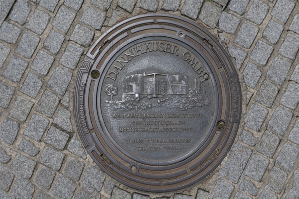 Manhole cover with self-advertising of the manhole cover manufacturer, Bad Kissingen, Lower Franconia, Bavaria, Germany, Europe