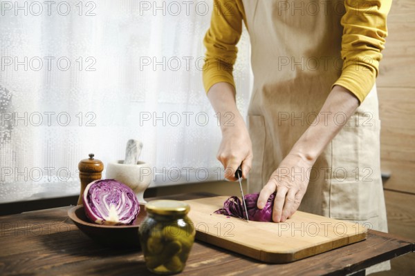 Unrecognizable man cutting purple cabbage in the kitchen