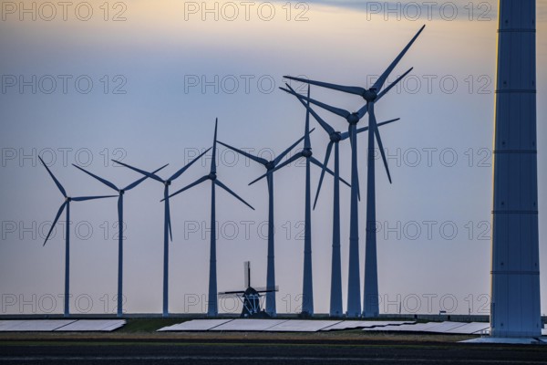 Windmill Poldermolen De Goliath stands between the high-tech wind turbines in Eemshaven, historic windmill from around 1882, rebuilt and reconstructed several times, Westereems wind farm, solar farm on sea dike, Slaperdijk, a good 5 kilometres long, Netherlands